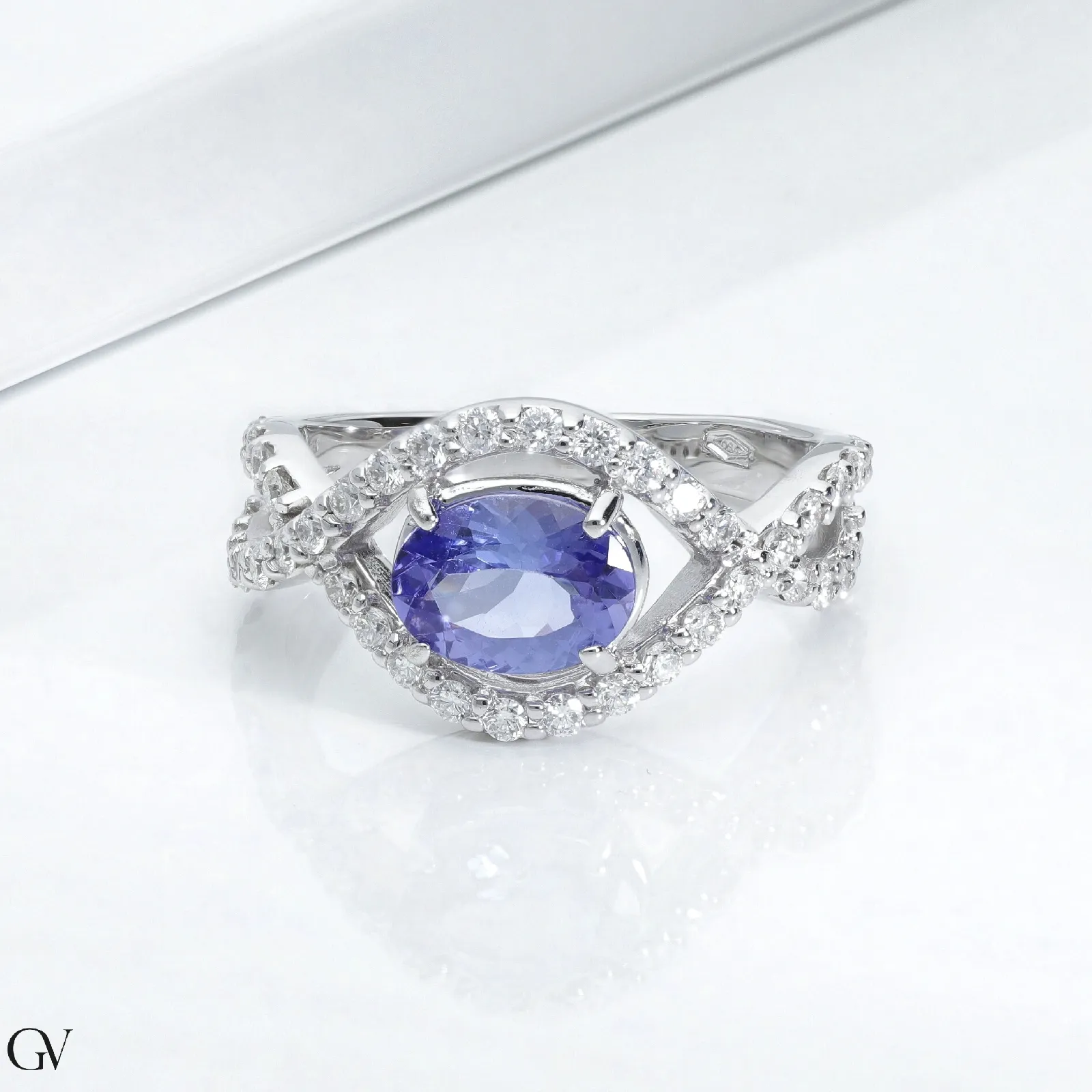 Anello in oro bianco 18k con tanzanite ovale, circa 6x7 mm, e diamanti